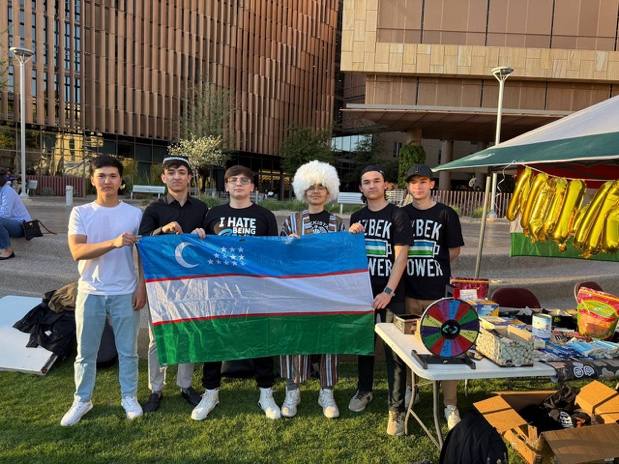 Students holding Uzbek flags at the Nowruz celebration